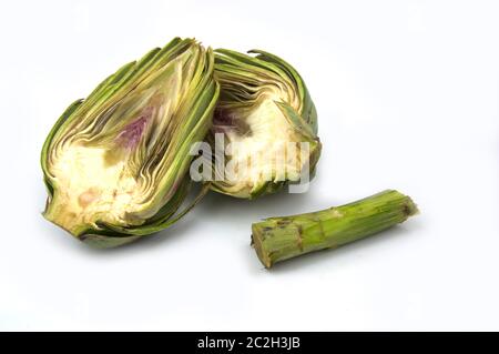 An artichoke cut in half next to the stem of the plant, all isolated on white background and with copy space Stock Photo