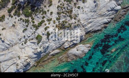 Mediterranean Greek landscape drone shot at Kavourotripes beach. Sithonia Chalkidiki peninsula aerial top view pan with rocky coastal & clear waters.