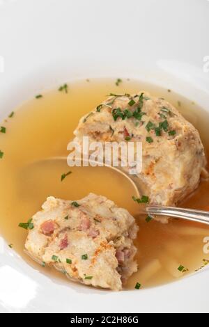 single speckknoedel in soup on wood Stock Photo