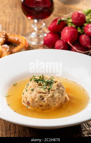 single speckknoedel in soup on wood Stock Photo