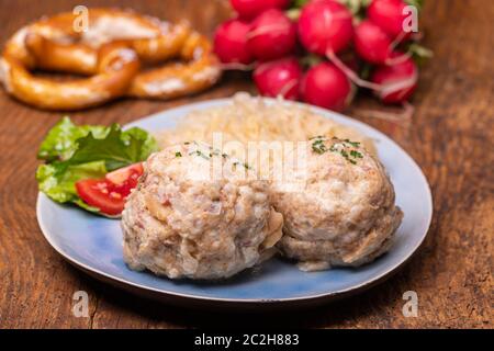 two speckknoedel with sauerkraut on wood Stock Photo