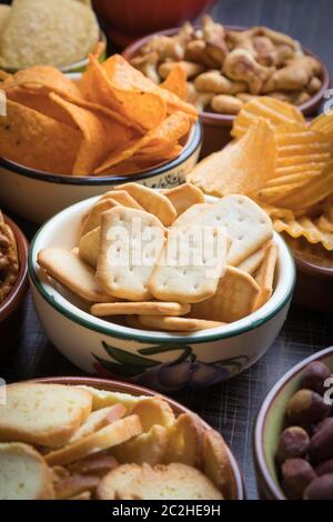 Salty snacks served as party food in ceramic bowls Stock Photo