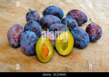 Fresh plums on a wooden plate Stock Photo