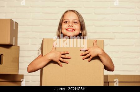 Packaging things. Move out concept. Delivering your purchase. Kid moving out. Moving routine. Prepare for moving. Rent house. Real estate. Make moving easier. Girl small child carry cardboard box. Stock Photo