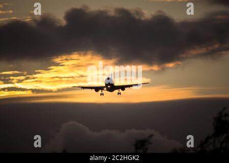 air plane in sunset sky Stock Photo