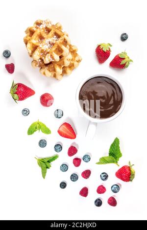 Breakfast with fresh fruit, hot chocolate, and Belgian waffles, a flat lay composition, shot from the top on a white background Stock Photo