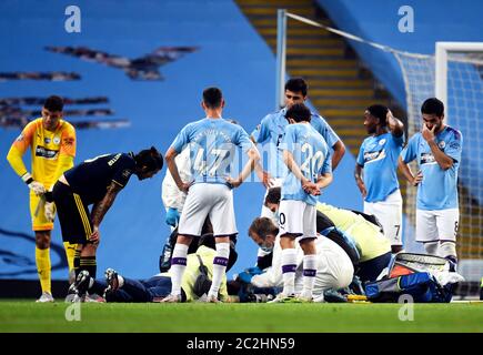 Manchester City's Eric Garcia receives treatment on the floor after a collision with goalkeeper Ederson (left) during the Premier League match at the Etihad Stadium, Manchester. Stock Photo