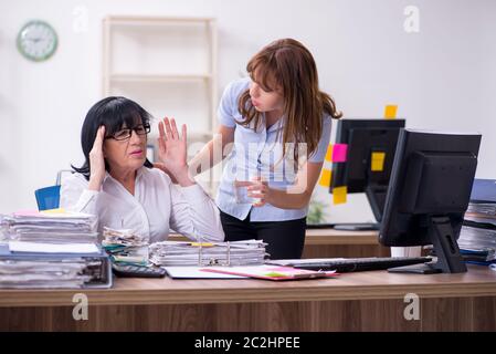 Two employees and excessive work in the office Stock Photo