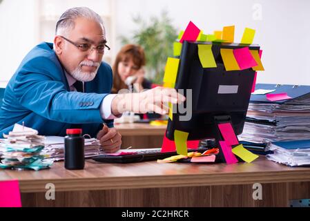 Two employees and excessive work in office Stock Photo