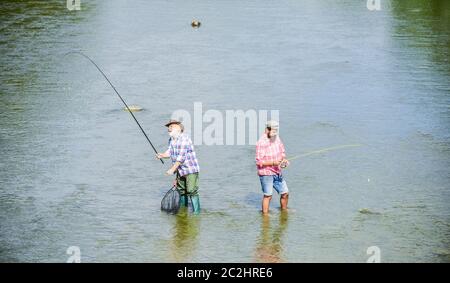 very long. father and son fishing. adventures. Big game fishing. male friendship. two happy fisherman with fishing rod and net. recreation and leisure outdoor. hobby and sport activity. Trout bait. Stock Photo