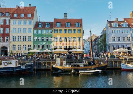 Colourful facades and restaurants on Nyhavn embankment and old ships along the Nyhavn Canal Stock Photo