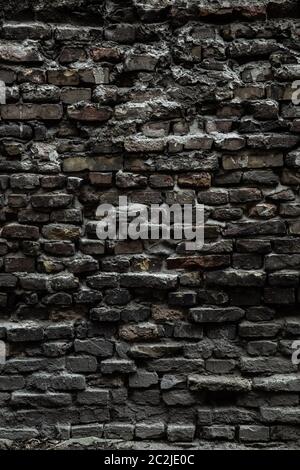 Urban black brick wall texture old masonry background. Gloomy background, black brick wall of dark stone texture Stock Photo