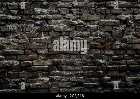 Urban black brick wall texture old masonry background. Gloomy background, black brick wall of dark stone texture Stock Photo