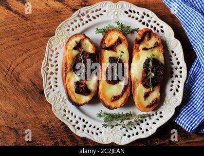 Sandwich with mozzarella sundried tomatoes and thyme on wooden table Stock Photo