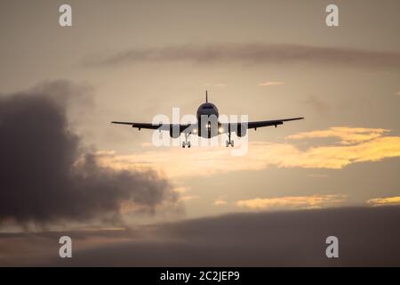 air plane in sunset sky Stock Photo