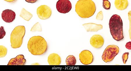 A panorama of dry fruit and vegetable chips, healthy vegan snack, on a white background, forming a frame with a place for text Stock Photo