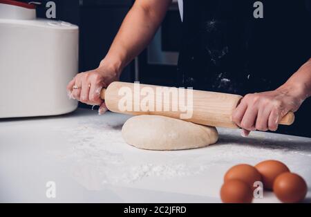 Hand of baker woman female making dough with rolling wooden Stock Photo
