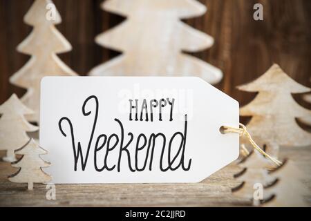 Label With English Text Happy Weekend. White Wooden Christmas Tree As Decoration. Brown Wooden Background Stock Photo