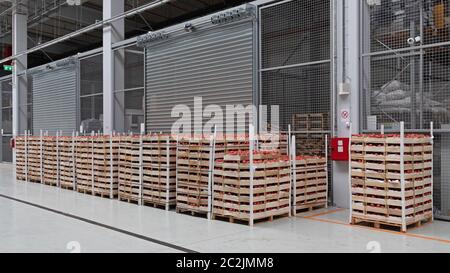 Crates of Tomato at Pallets in Warehouse Stock Photo