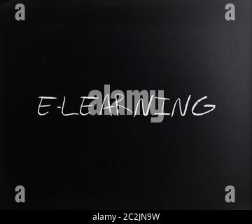 "E-learning" handwritten with white chalk on a blackboard. Stock Photo