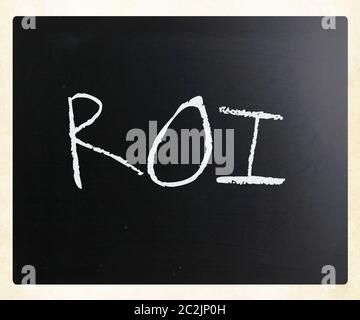 The word "ROI" handwritten with white chalk on a blackboard. Stock Photo