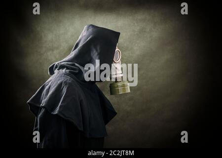 Man in a gas mask and hooded cloak. Environment pollution. Stock Photo