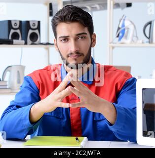 Young repairman fixing and repairing microwave oven Stock Photo