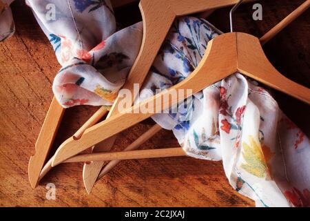 Wooden empty clothes hangers on wooden background. What nothing to wear concept. Woman clothing Stock Photo