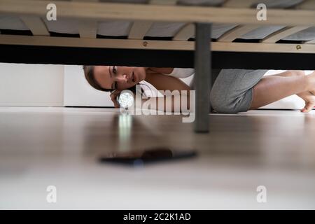 Woman Lost Smartphone And Found It Under Bed Stock Photo