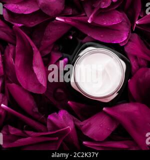 Sensitive skincare moisturizer cream on purple flower petals background, natural science for skin Stock Photo