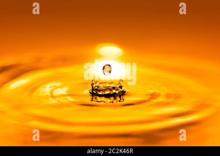 Closeup on drop of cosmetic golden oil liquid. Stock Photo