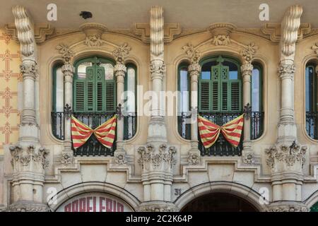 Catalan national flags placed on the French balconies on the Cases Ramos in Barcelona, Catalonia, Spain. The building designed by Catalan modernist architect Jaume Torres i Grau was constructed between 1906 and 1908 on Plaça de Lesseps (Plaza de Lesseps). Stock Photo