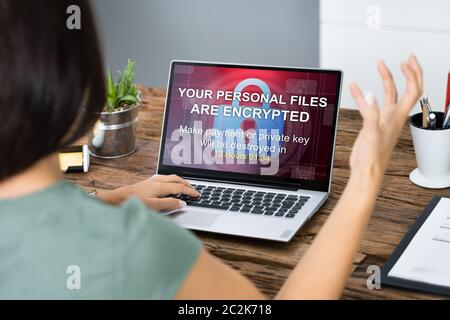 Close-up Of A Sad Businesswoman With Laptop Screen Showing Personal Files Encrypted Text Stock Photo