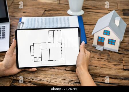 Architect Analyzing House Floor Plan On Digital Tablet Stock Photo