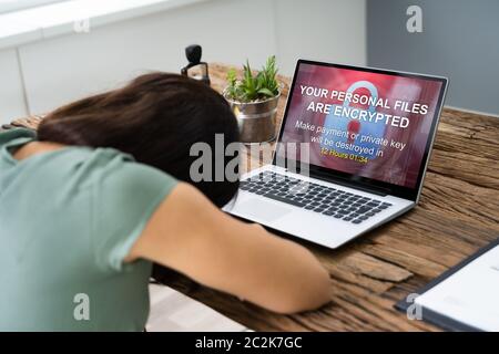 Close-up Of A Sad Businesswoman With Laptop Screen Showing Personal Files Encrypted Text Stock Photo