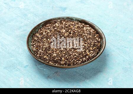 A bowl of chia seeds on a blue background Stock Photo
