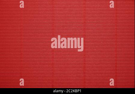 Close up background pattern texture of vivid scarlet red corrugated packaging cardboard Stock Photo