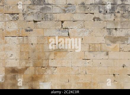 Wall of white and gray adarce travertine stone brick blocks, close up background texture, side view Stock Photo