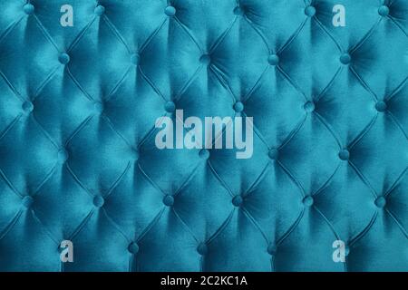 Teal blue velvet capitone textile background, retro Chesterfield style checkered soft tufted fabric furniture diamond pattern decoration with buttons, Stock Photo