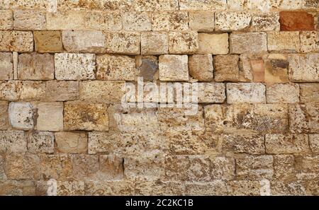 Wall of white and brown antique limestone stone brick blocks, close up background texture, side view Stock Photo