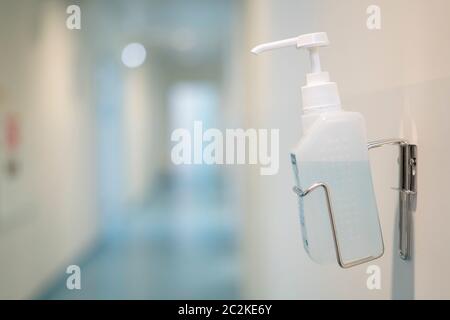 Hand sanitizer gel bottle on the wall of a public space Stock Photo