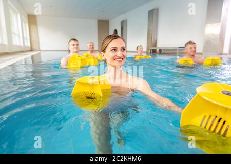 Young woman in water pool during aquarobics class Stock Photo