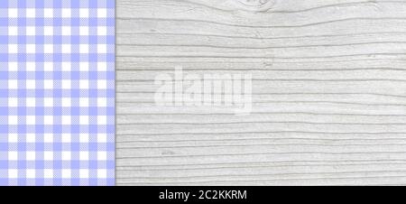 Light grey wooden plank with purple blue white checkered tablecloth Stock Photo