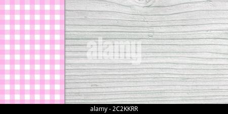 Light grey wooden plank with purple blue white checkered tablecloth Stock Photo