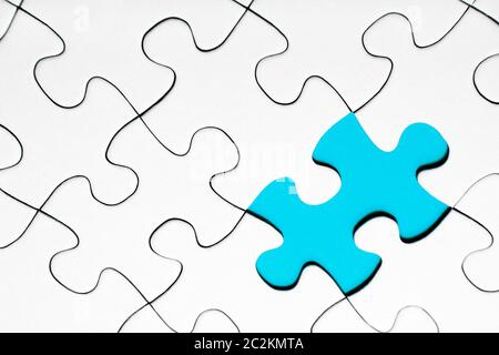 Light blue puzzle piece in between of white puzzle pieces, business concept Stock Photo