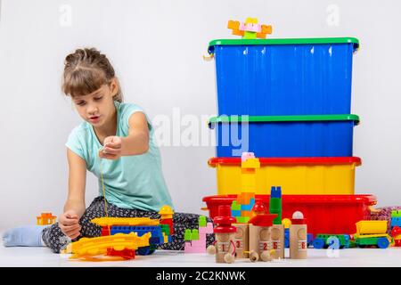 Girl alone plays constructor and other toys Stock Photo