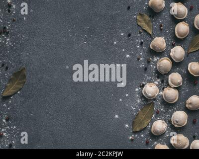 Beautiful scattered raw pelmeni on marble background Stock Photo