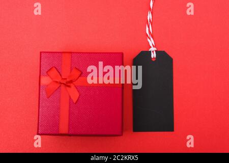 Red tag label and red grift box on black background, blank copy space for you work, Online marketing shopping concept Stock Photo