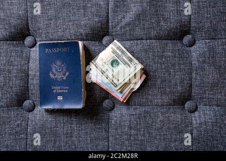 Old well-used US passport next to US and international currency Stock Photo
