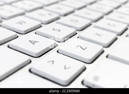 Close-up detail of a computer keyboard with white keys and a gray background. Letters and symbols on the keys. Technology and communication via the in Stock Photo